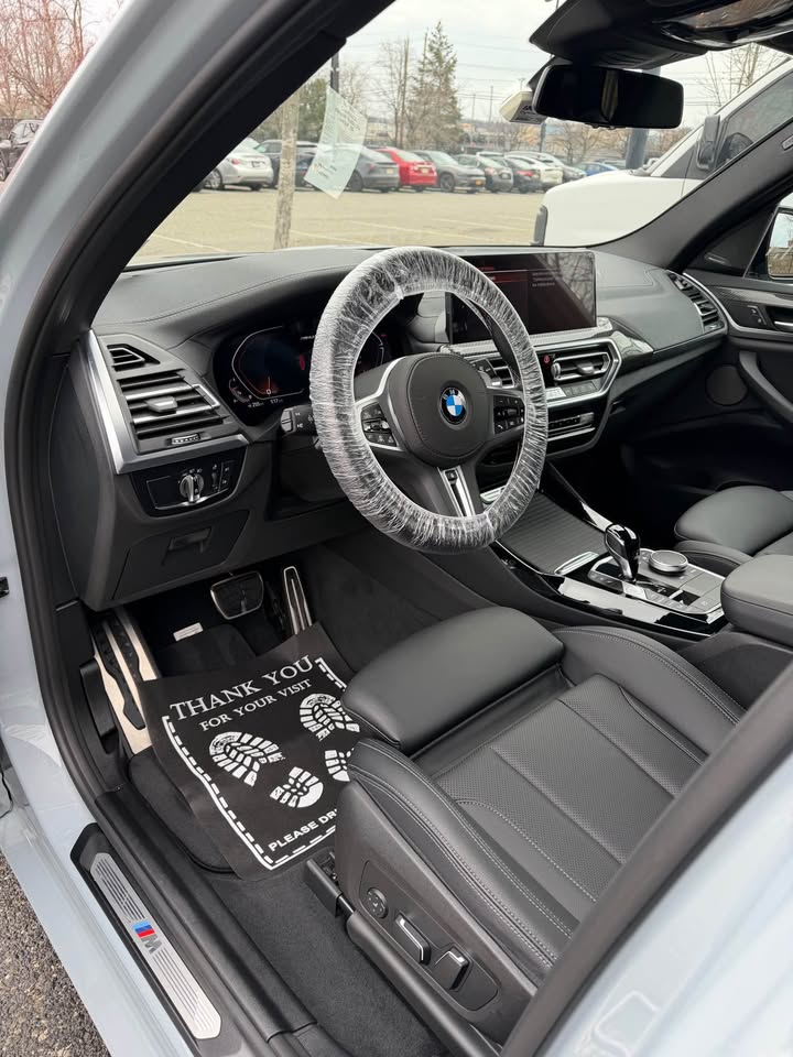Freshly detailed BMW interior with protected steering wheel and floor mats
